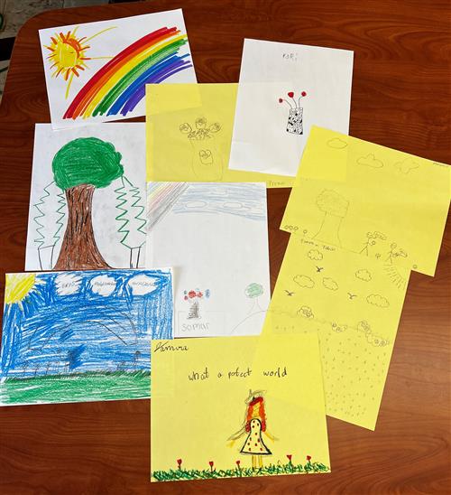 Photo shows student artwork inspired by the lyrics of Armstrong's "What a Wonderful World." Includes drawings of a rainbow. 
